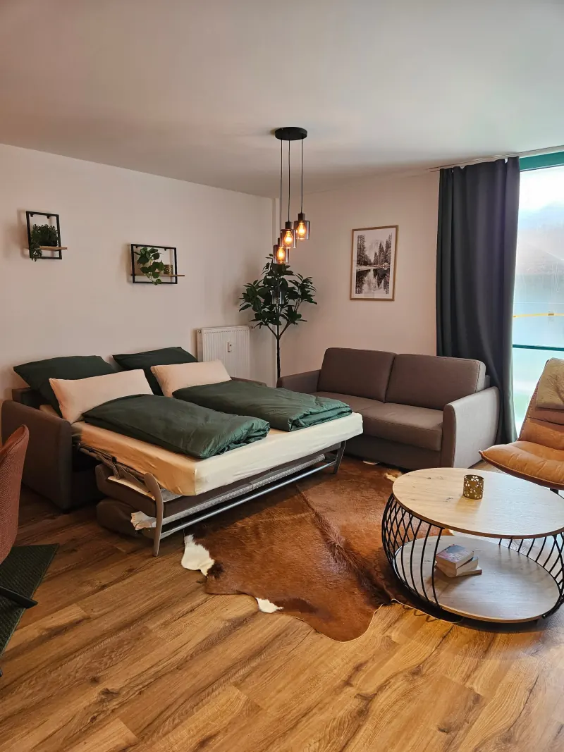 Ferienwohnung Karkopfblick: Wohnzimmer mit ausgezogener Schlafcouch