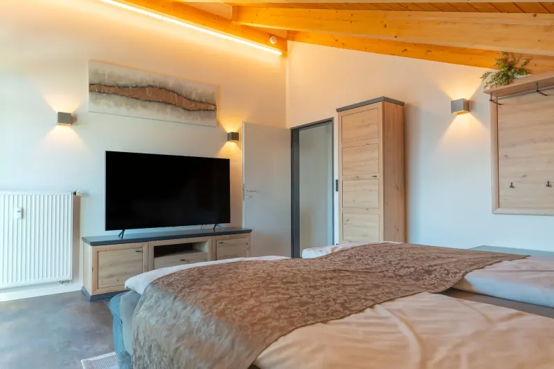 Ferienwohnung Untersbergblick: Romantik-Schlafzimmer mit Fernseher unter der Holzdecke